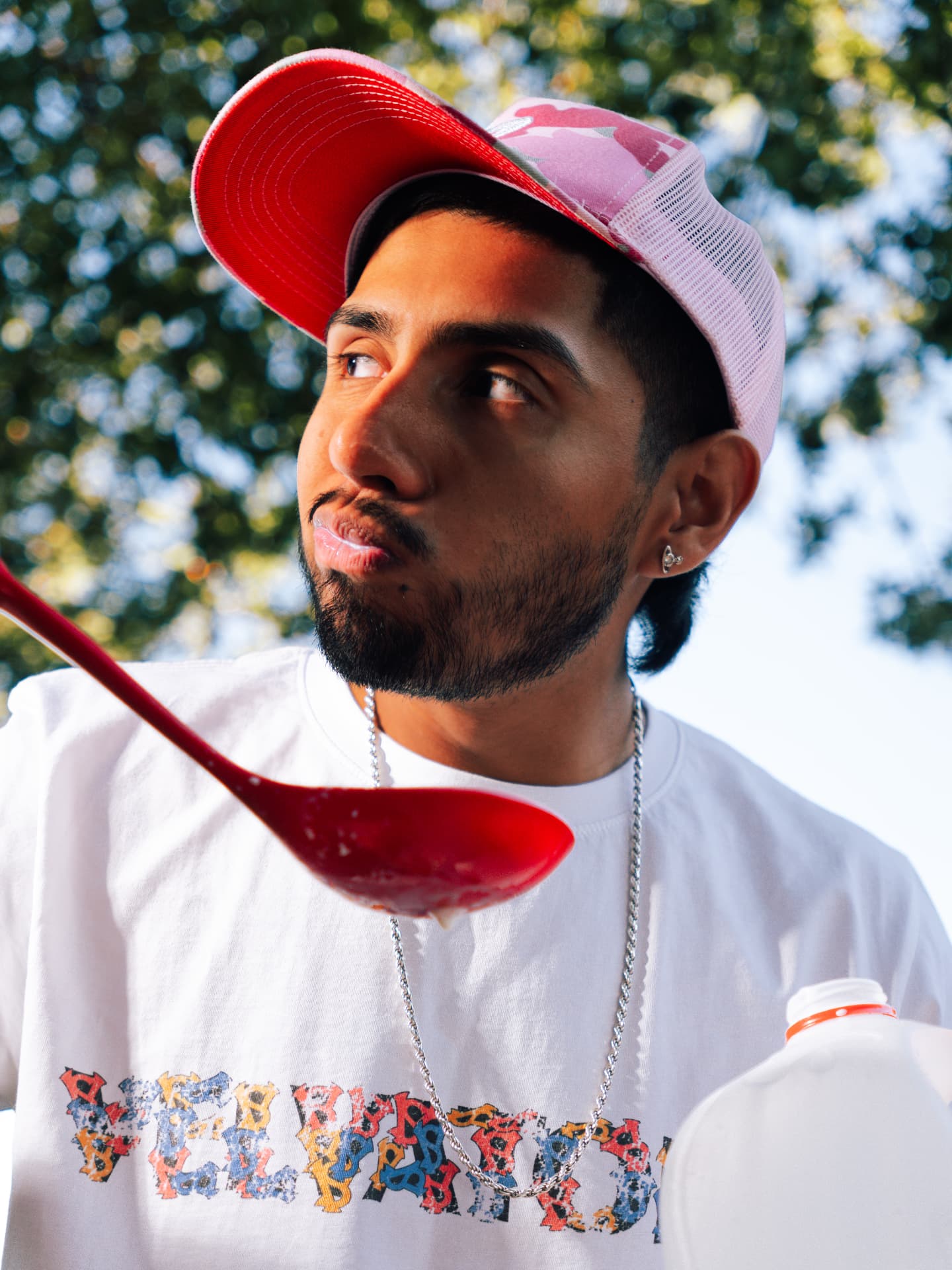 Model in pink trucker cap wearing the VELVATONE tee